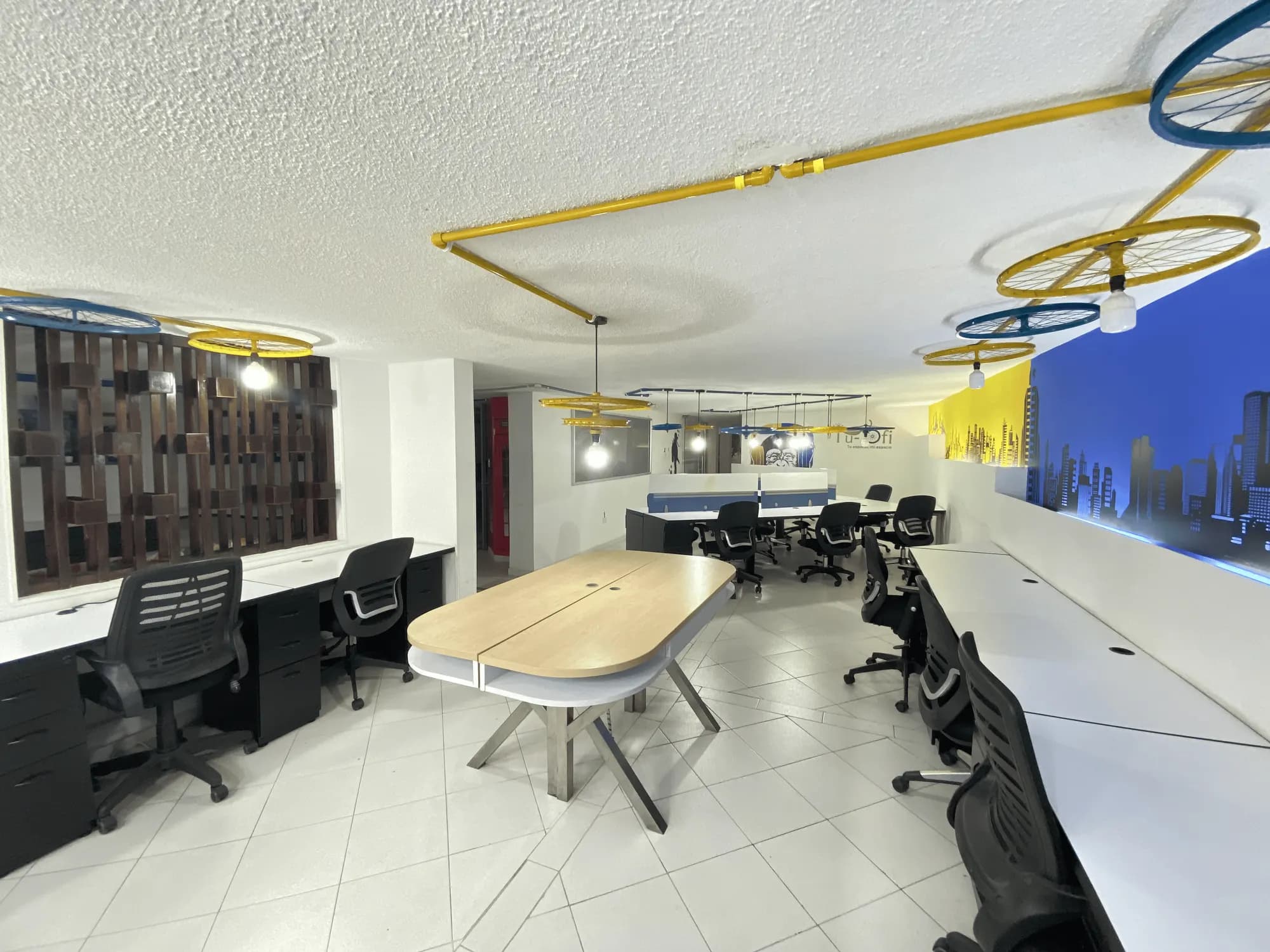 Área de coworking de Tu-Ofi con escritorios y lámparas de colores