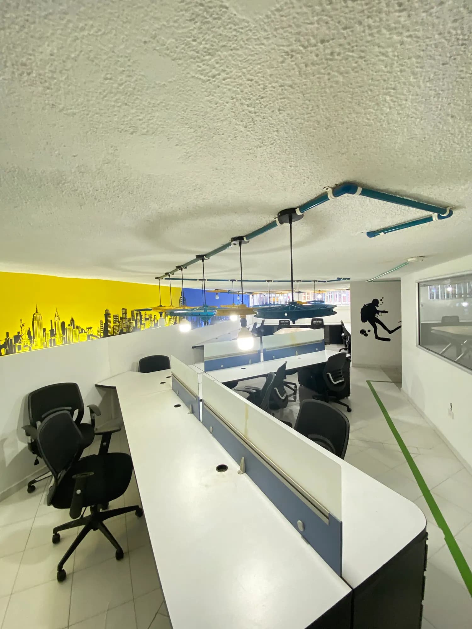 Coworking con pared amarilla y lámparas