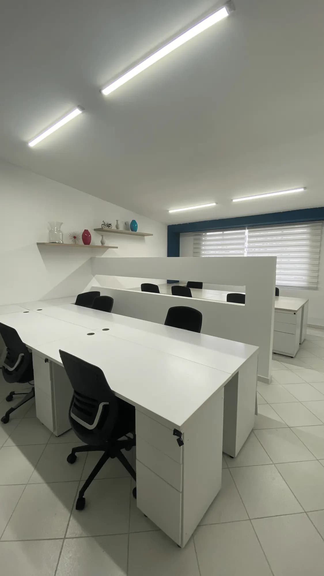 Escritorios blancos con sillas ergonómicas