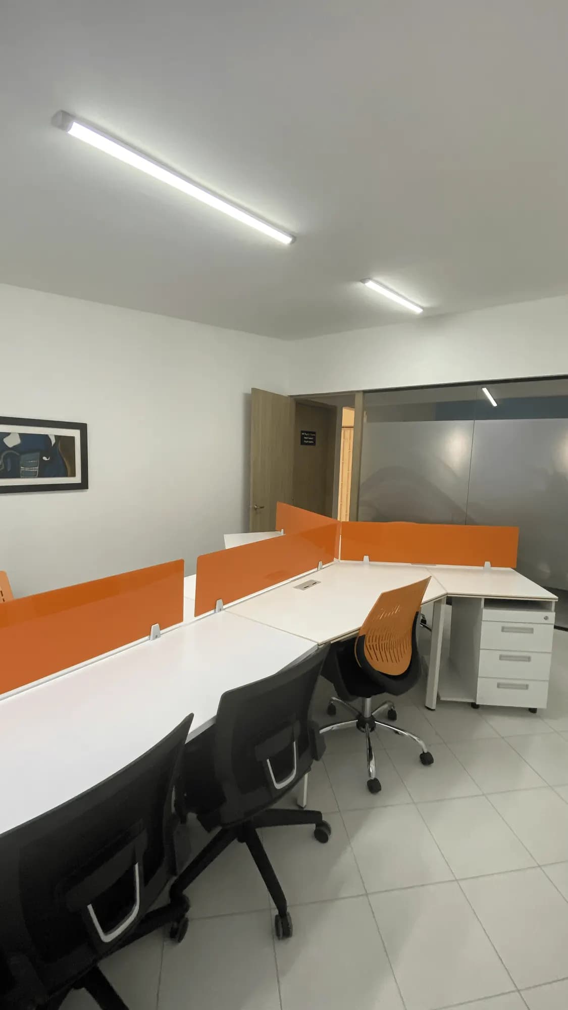 Fila de escritorios dedicados con divisores naranja
